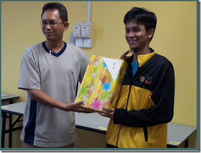 Nik Ahmad Farouqi receiving his Champion's prize from the sponsors.