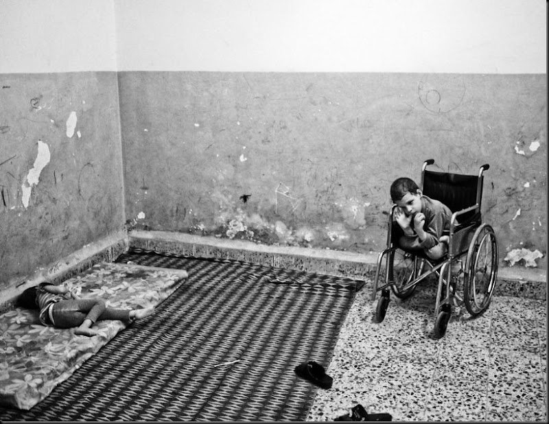 Aziz, 8, (right) and his sister Aisha (left), both suffering from cerebral palsy, inside their family's one-room house in East Amman, an area where a large number of Syrian refugees have settled. (Moises Saman/Magnum Photos for Save the Children)