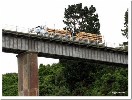 Logging truck slowly passing over the Waimakariri Gorge road bridge.