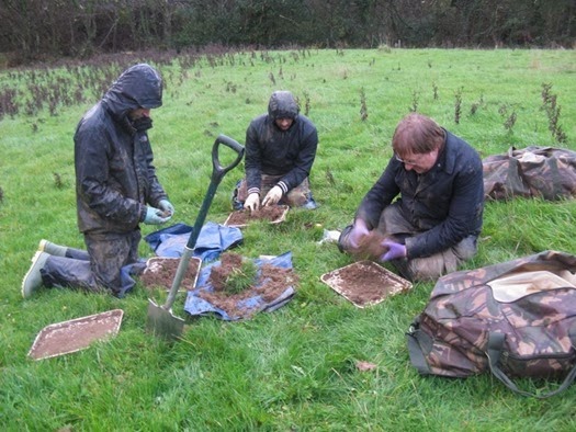 A wet and muddy Soil Biodiversity Group in the rain in Dorset