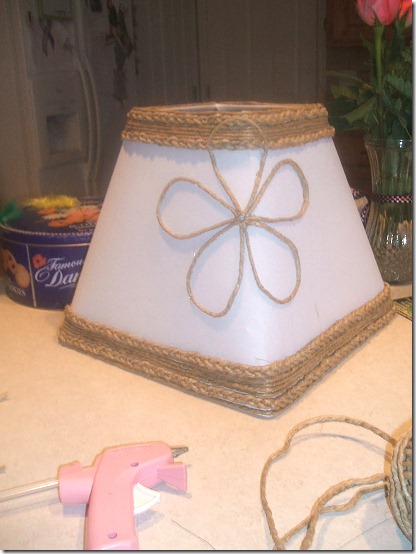 White lamp shade trimmed with jute and embellished with jute flower