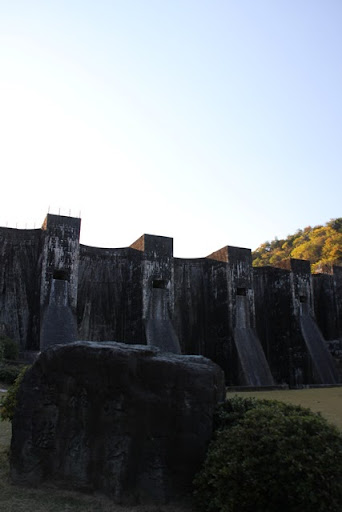 Vista del monumento in pietra e dell'argine da valle.