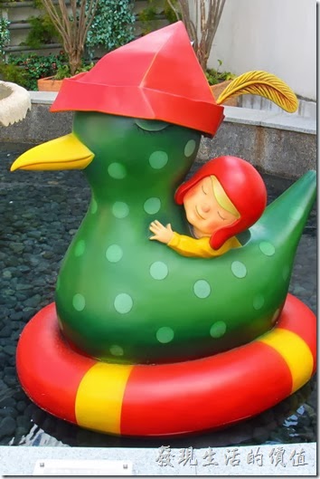 花蓮-翰品酒店。（和水鴨繞圈圈的下午）水池內有隻帶著紅色帽子的水鴨與同樣戴在紅色風帽的小孩正在水池內繞圈圈相依偎。