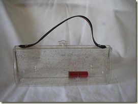 This clear Lucite purse was owned by Janine in the early 1960's. Her red, red Elizabeth Arden Lipstick is still inside.  Find it here