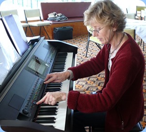 Denise Gunson taking advantage of Coffee Day to familiarize with the Clavinova ready for her Concert for the Club in September. Photo courtesy of Dennis Lyons.