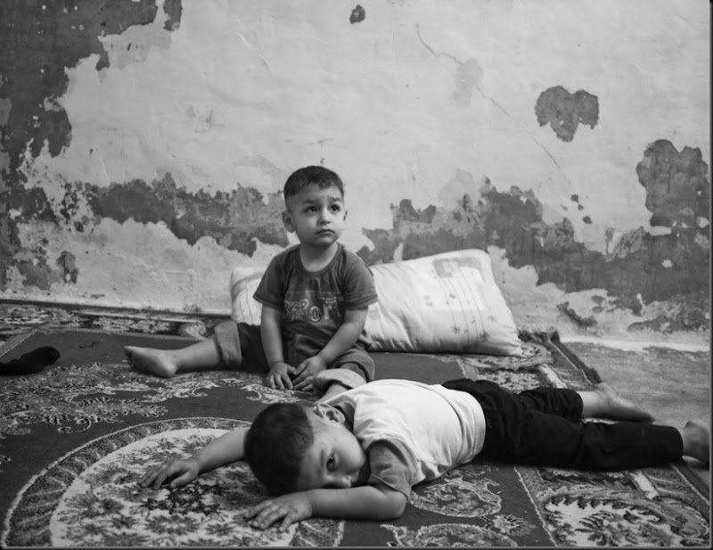 Qais (front) and his brother Laith, inside their one-room house in Amman. Qais and Laith live with their mother and grandmother, their father is missing in Syria. (Moises Saman/Magnum Photos for Save the Children)