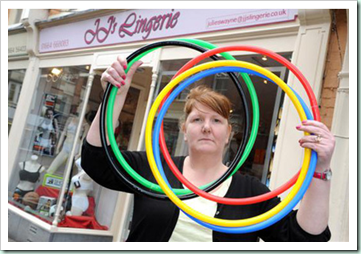 656160-4 : ©Lionel Heap : Melton News : JJ Lingerie in Melton Mowbray Ordered to Remove Olympic Rings Shop Window Display : Owner of JJ Lingerie Julie Swayne with the rings she has been ordered to remove from her shop window by trading standards.
