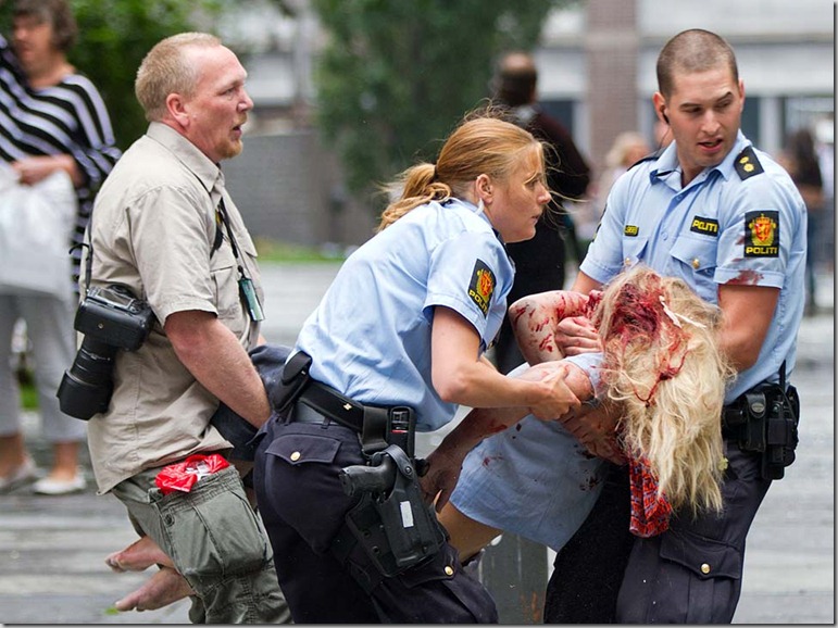 A young victim is helped in the centre of Oslo, Friday July 22, 2010, following an explosion that tore open several buildings including the prime minister's office, shattering windows and covering the street with documents.(AP Photo/Winje √jijord, Scanpix Norway) NORWAY OUT: