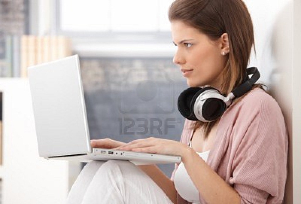 [9435067-young-woman-busy-using-laptop-computer-concentrating-on-screen-having-headphones-in-neck%255B2%255D.jpg]