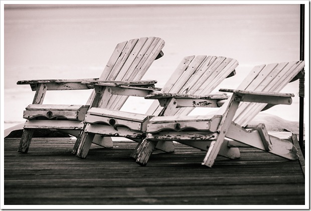 three white muskoka chairs on Lake Simcoe