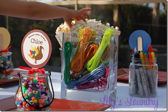 Thanksgiving kids table decorating and activity ideas--jars with beads and twine to make jewelry and crafts, paper cones filled with popcorn