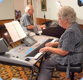 Barbara and Rob Powell played some solo pieces and some duets. Here they are duetting with Barbara playing their lovely Yamaha Tyros 5 (76 note version) and Rob on our Clavinova. Photo courtesy of Dennis Lyons.