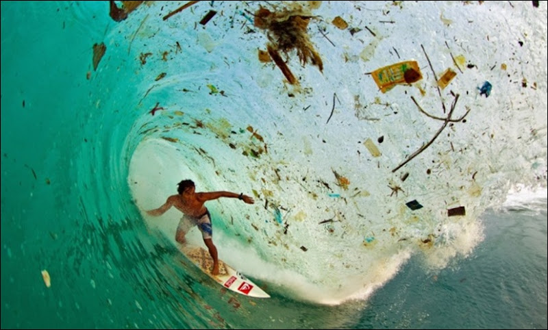 Indonesian surfer Dede Surinaya onda com lixo na ilha de Java