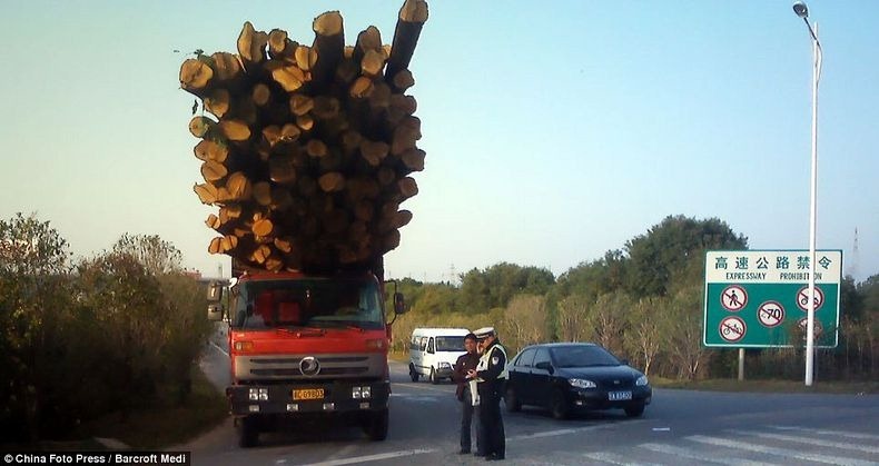 Video of overloaded truck teetering past pedestrians with inches to spare  in China