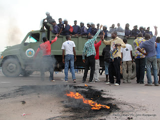 Un véhicule de Fardc passe avec des éléments de la PNC devant des partisans de l’UDPS  le 26/11/2011 le long du boulevard Lumumba à Kinshasa, lors de l’arrivé d’Etienne Tshisekedi en provenance du Bas-Congo. Radio okapi/ Ph. John Bompengo