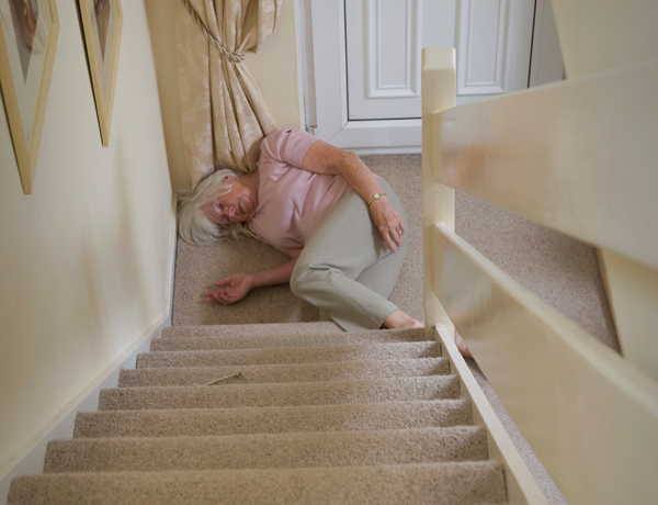 elderly woman lying at the foot of domestic stairs