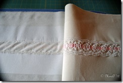 The flounce with the insertion lace sewn on, showing the tear-away stabilizer ironed onto the wrong side of the fabric.