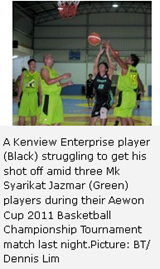 A Kenview Enterprise player (Black) struggling to get his shot off amid three Mk Syarikat Jazmar (Green) players during their Aewon Cup 2011 Basketball Championship Tournament match last night.Picture: BT/ Dennis Lim 