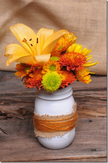 Painted mason jar wrapped with jute used as a vase for summer flower arrangements