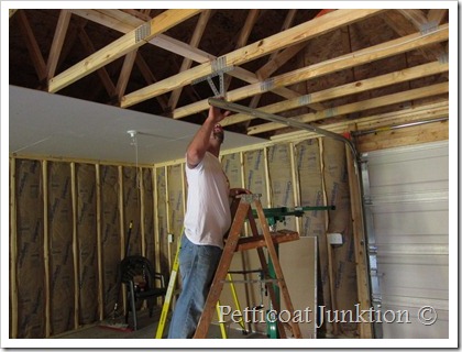 Jay hanging drywall in the Owen Workshop Petticoat Junktion