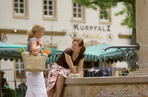 Two women at the fountain in the townsquare of Königsplatz, Germany. 