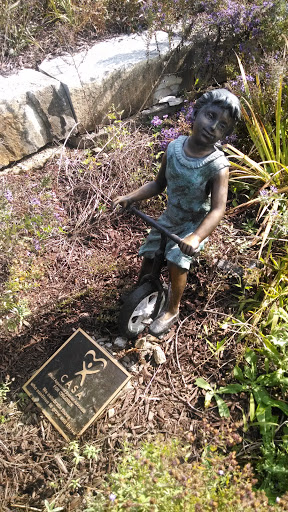 Statue Of Girl On A Tricycle
