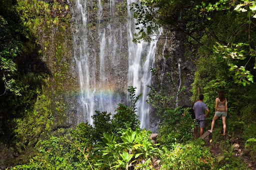 A couple takes in Wailua Falls in Hana on the east side of Maui.