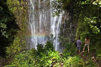 A couple takes in Wailua Falls in Hana on the east side of Maui.