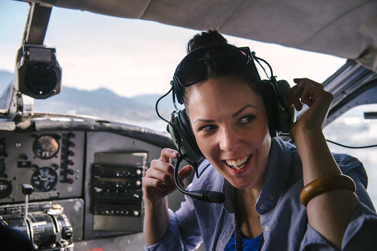 A young woman checks out the pilot's seat inside a Harbour Air Floatplane in Vancouver, British Columbia.