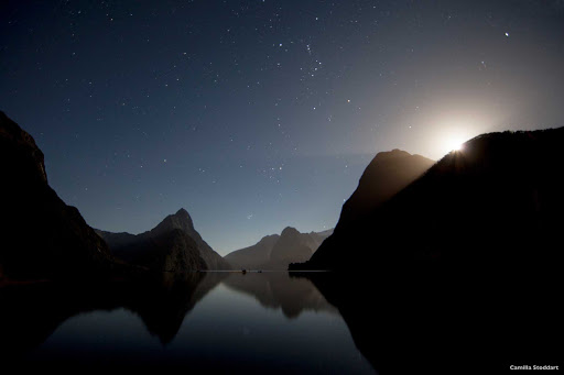 Moonset_Milford_Sound - As the moon sets behind the towering peaks of Milford Sound, it’s easy to see why the Te Wahipounamu World Heritage Area is known as the land that time forgot. During the day you can cruise along the sound, get close to towering waterfalls, wave to playful seals and marvel at the rainforest that clings to the cliffs. Pre- or post-cruise is your best option here.