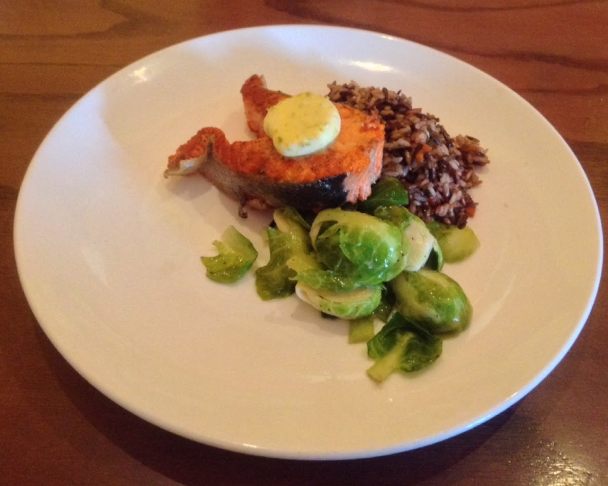 Salmon steak served with rice pilaf and brussel sprouts.