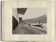 Kade met spoorwegrails en boten in de Emmahaven van Padang