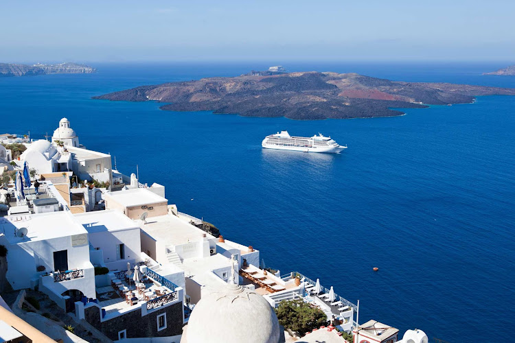 Seven Seas Mariner sails past the dramatic cliffs and pristine whitewashed buildings of Santorini.