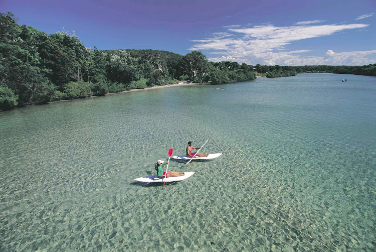 Kayakers paddle through turquoise waters at South West Rocks, Kempsey, North Coast NSW, Australia.