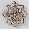 Star-shaped tile with an inscription and floral scrolls