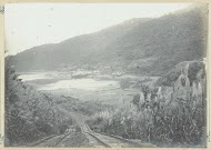 Spoorbaan in heuvelachtig landschap nabij zee in Frans-Indochina