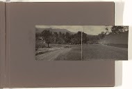 Auto op onverharde weg tussen velden in bergachtig landschap