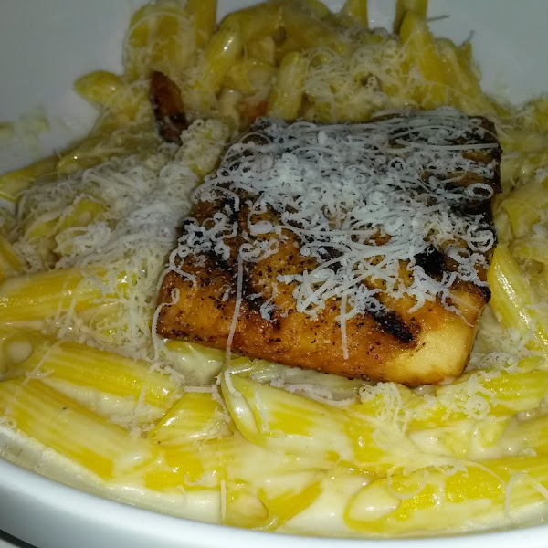 GF pasta in alfredo sauce topped with grilled salmon