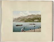 Strand bij Bellagio met roeiers en wassende vrouwen aan het Comomeer