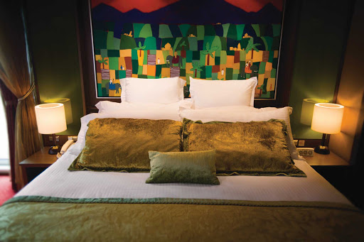 Get a relaxing night's sleep on a king-size bed in Norwegian Pearl's Deluxe Owner's Suite.
