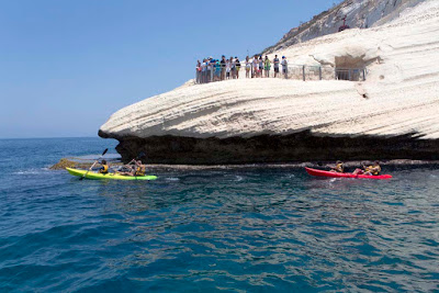 Kayakers paddle by Rosh Hanikra, Israel.
