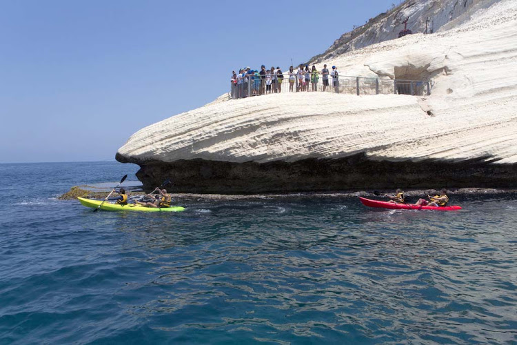 Kayakers paddle by Rosh Hanikra, Israel.