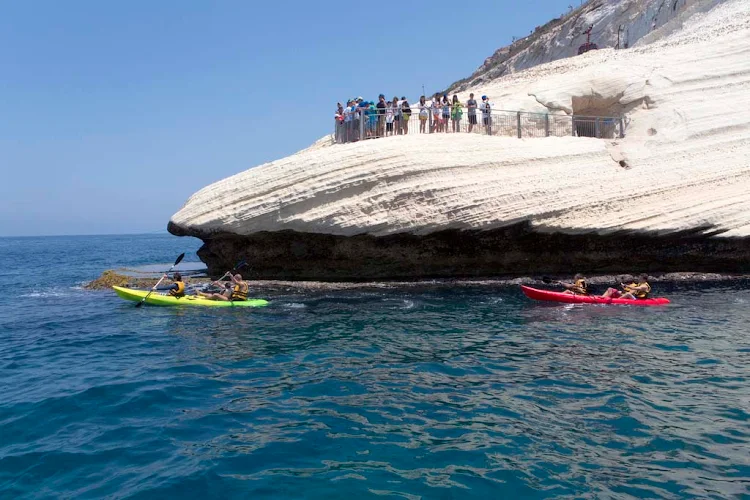 Kayakers paddle by Rosh Hanikra, Israel.