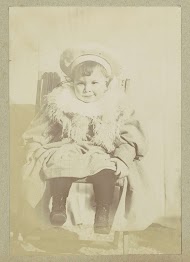 Portret van een jong kind met een jas, een sjaal en een muts