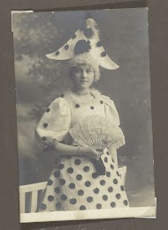 Portret van een jonge vrouw in een kostuum met stippen en een waaier