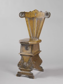 Stoel van notenhout, met achthoekige zitting. Schild met boom en versieringen in intarsia