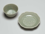 Bell-shaped cup and saucer with two hares and the moon in relief