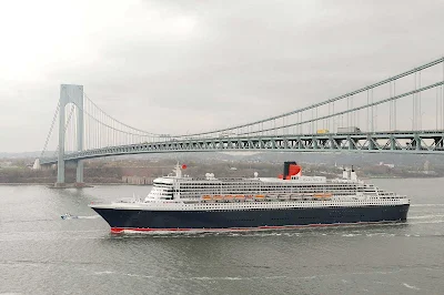 Queen Mary 2 sails beneath the Verrazano Bridge on the Hudson River in New York before making a transatlantic crossing.