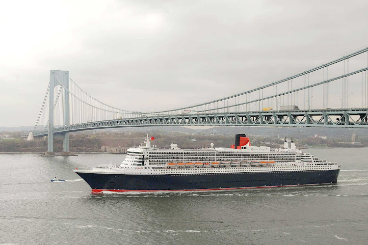 Queen Mary 2 sails beneath the Verrazano Bridge on the Hudson River in New York before making a transatlantic crossing.