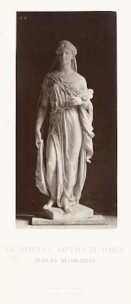 Marmeren beeld van een vrouw in gewaad en een sluier over haar hoofd, in haar linkerhand draagt zij een bos bloemen.